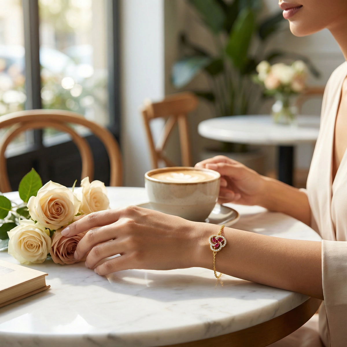 wear 18k gold plated bracelet person holding a cup of coffee with flowers on a table in a cafe.
