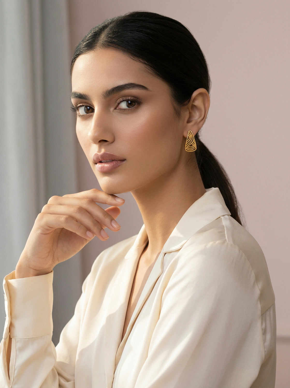 woman wearing a white blouse with a neutral background