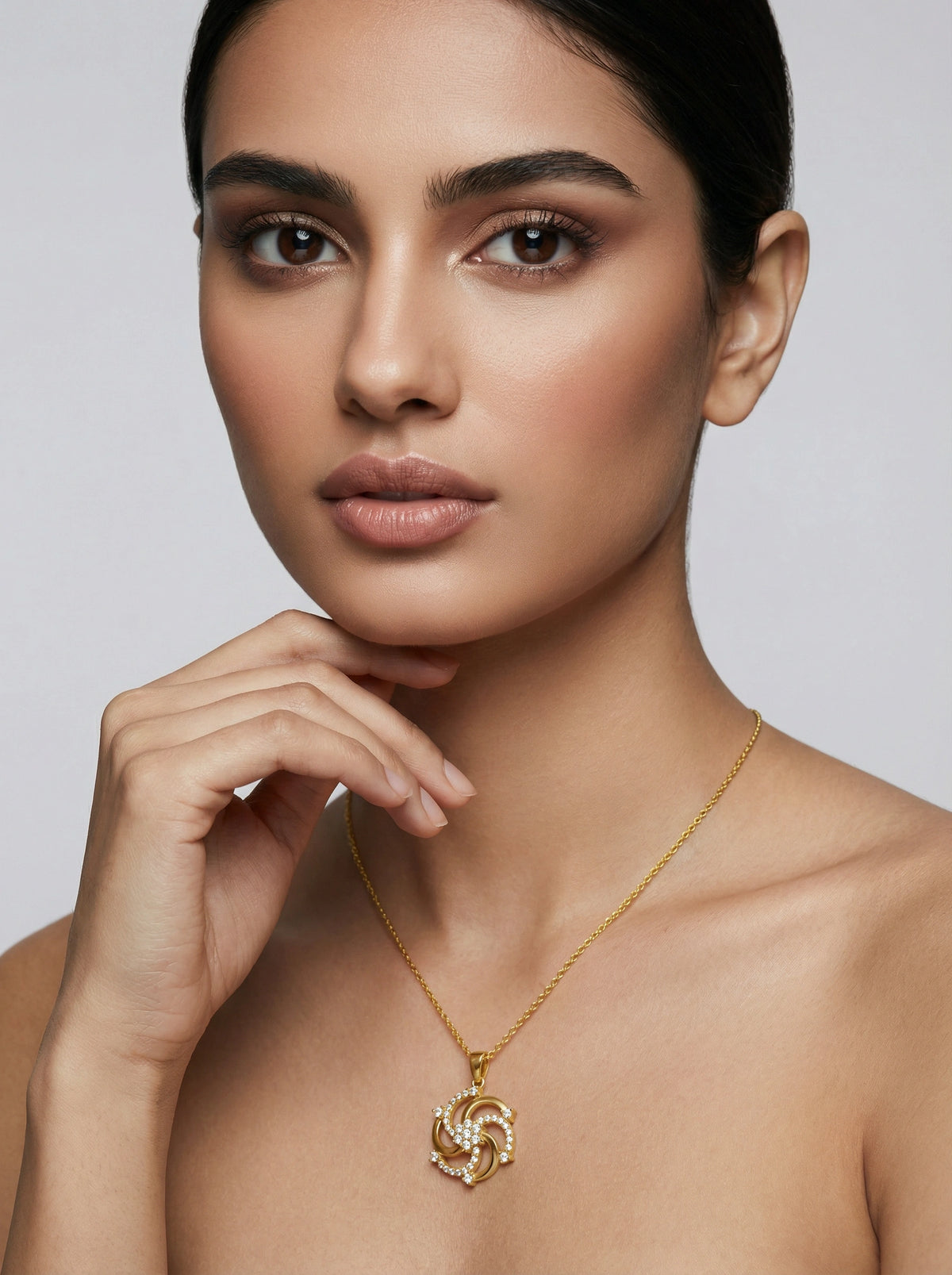 woman wearing a 18k gold plated necklace with a heart pendant against a neutral background