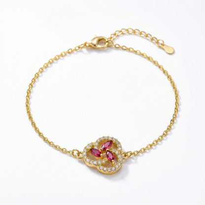 18k Gold plated bracelet with a heart-shaped clasp featuring red gemstones on a white background