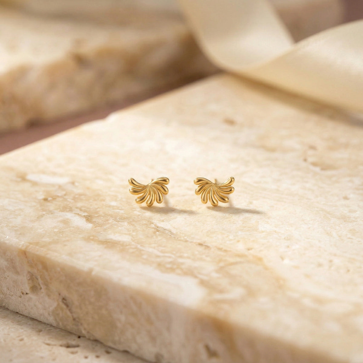 18k gold plated butterfly-shaped earrings on a marble surface