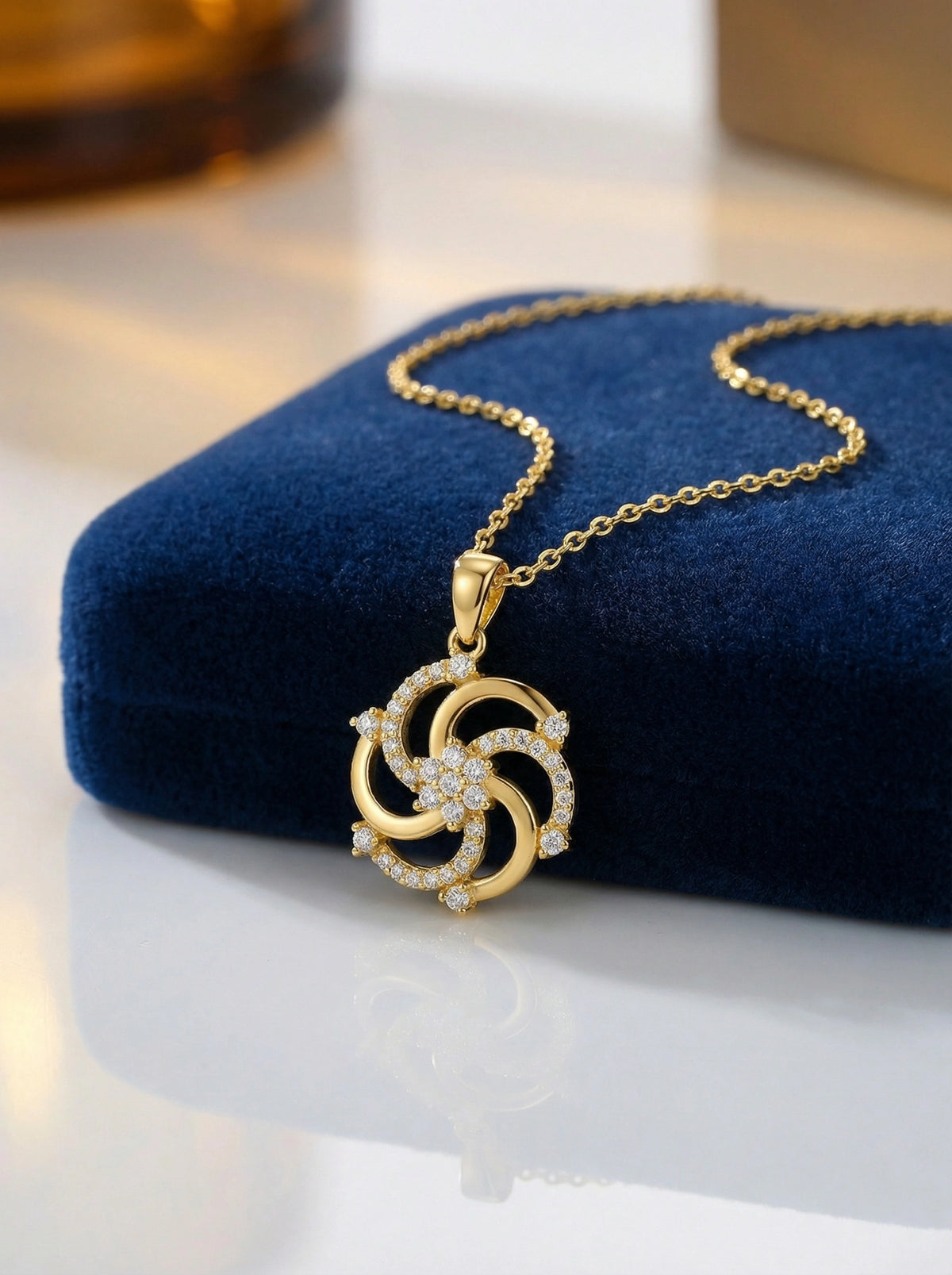18k gold plated necklace with a intricate pendant on a blue cushion