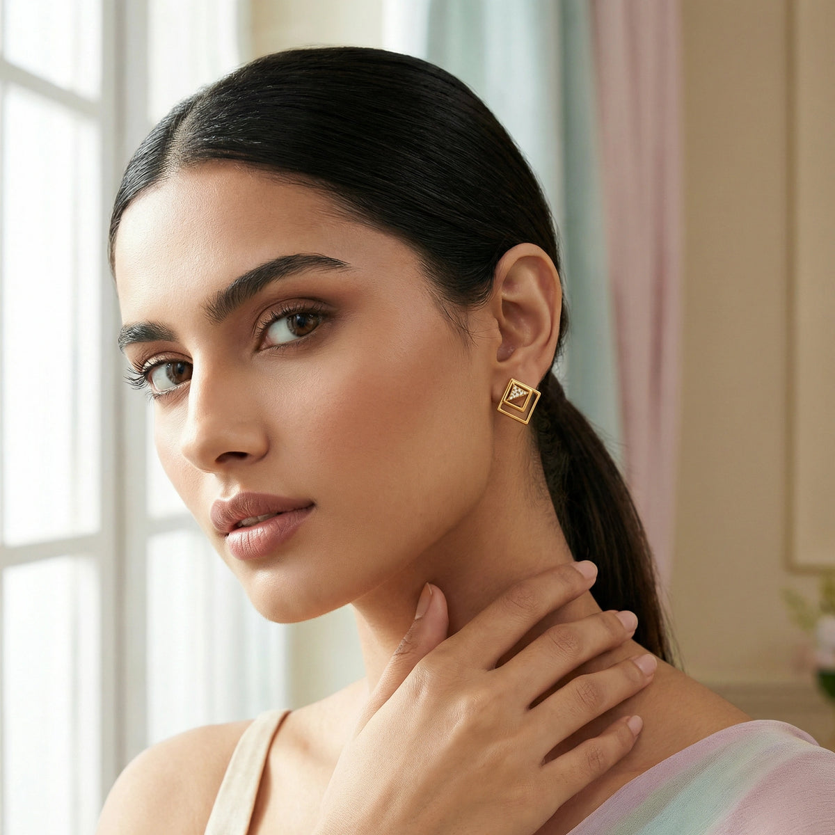 woman wearing 18k gold plated earrings in a softly lit room
