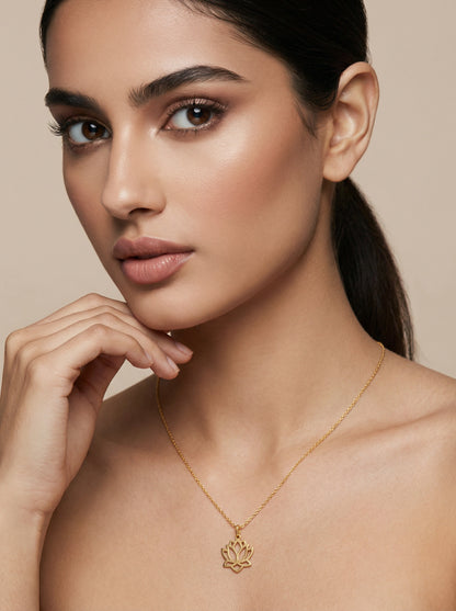 Woman wearing a 18k gold plated necklace with a lotus pendant against a beige background