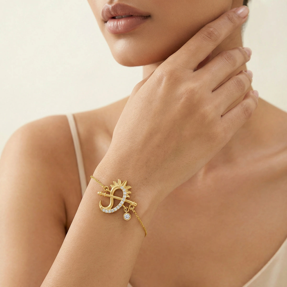 18k gold plated bracelet with a sun design worn by a model against a neutral background