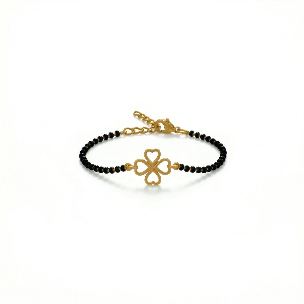 gold bracelet with black beads and clover charm on a white background