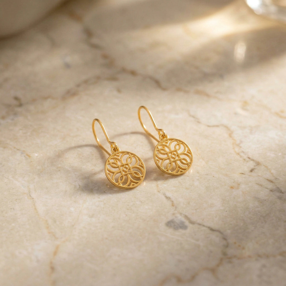 18k gold plated earrings on a marble surface