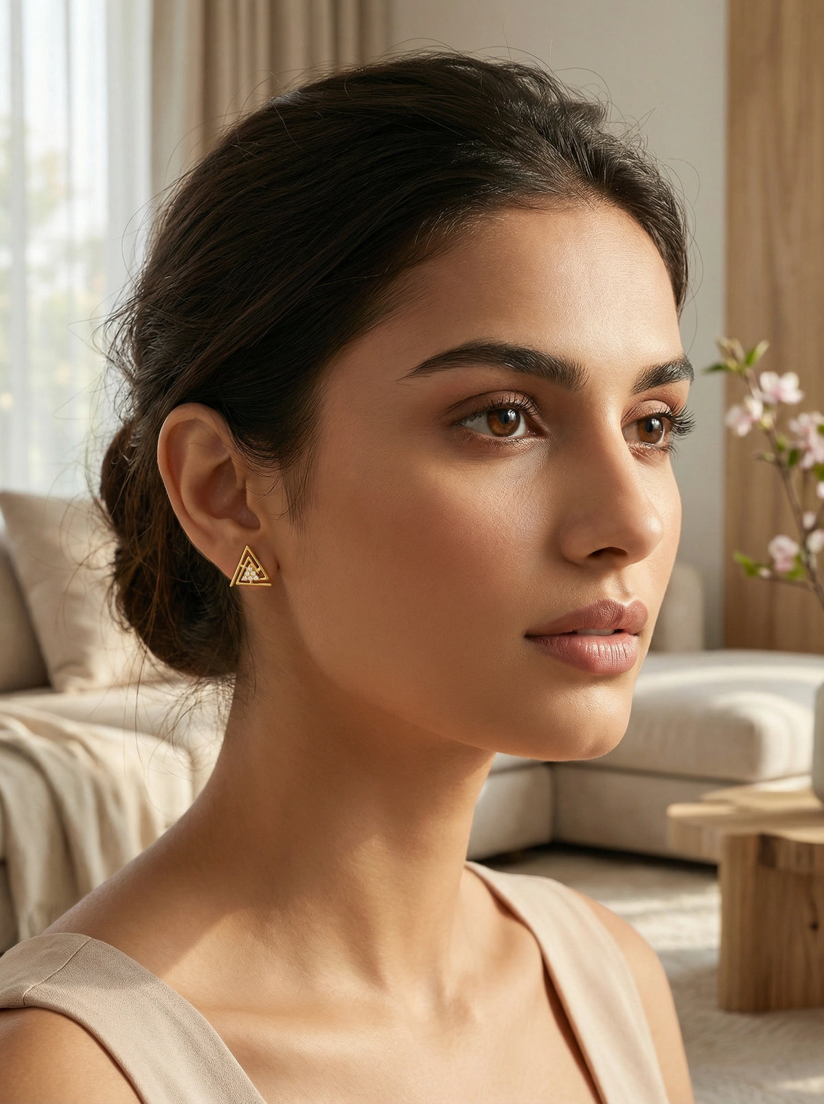woman wearing 18k gold plated  triangle earrings in a living room setting