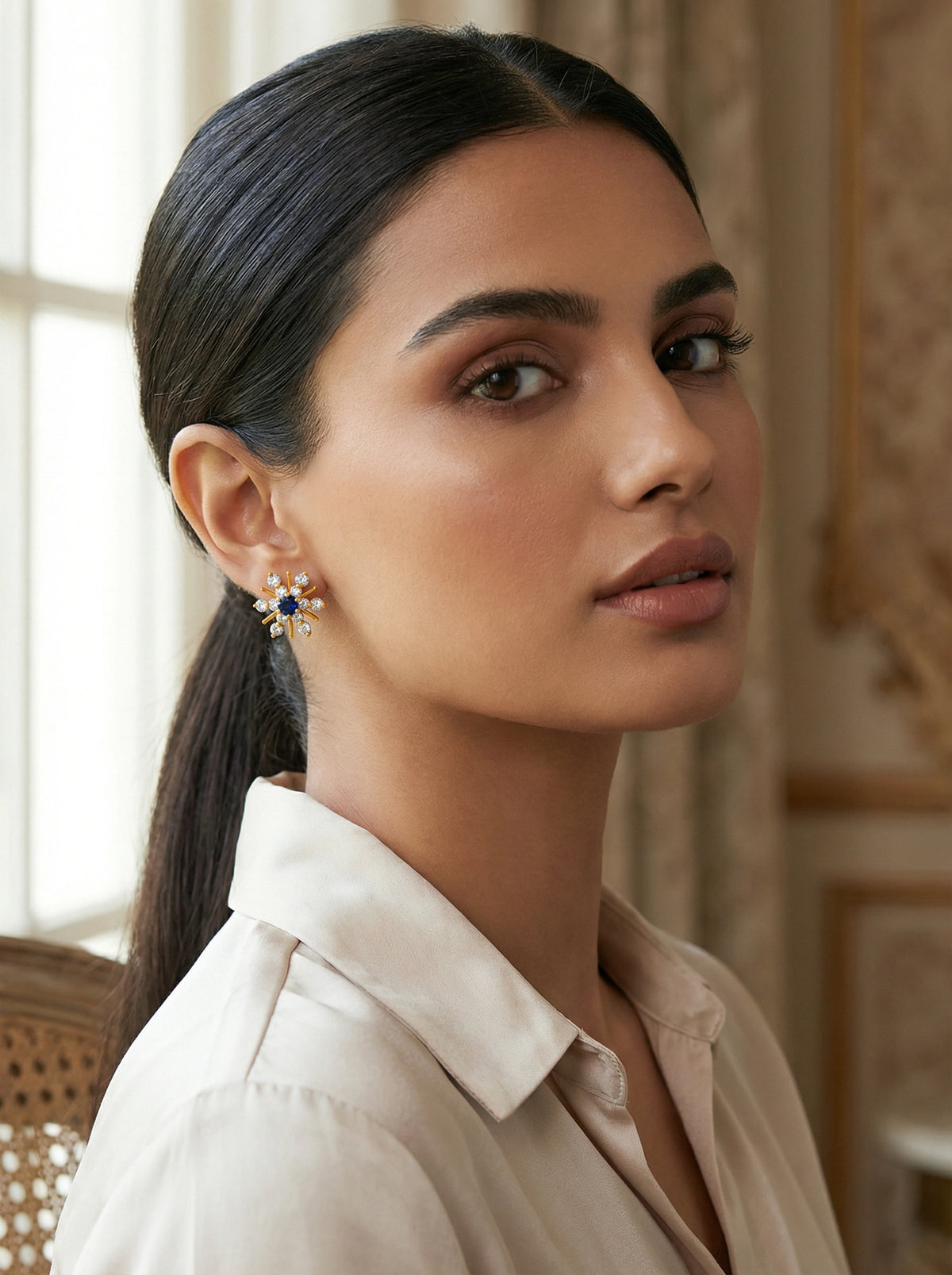 woman wearing a white blouse with a blurred background wear 18k gold plated navy blue gemstone earing stud 
