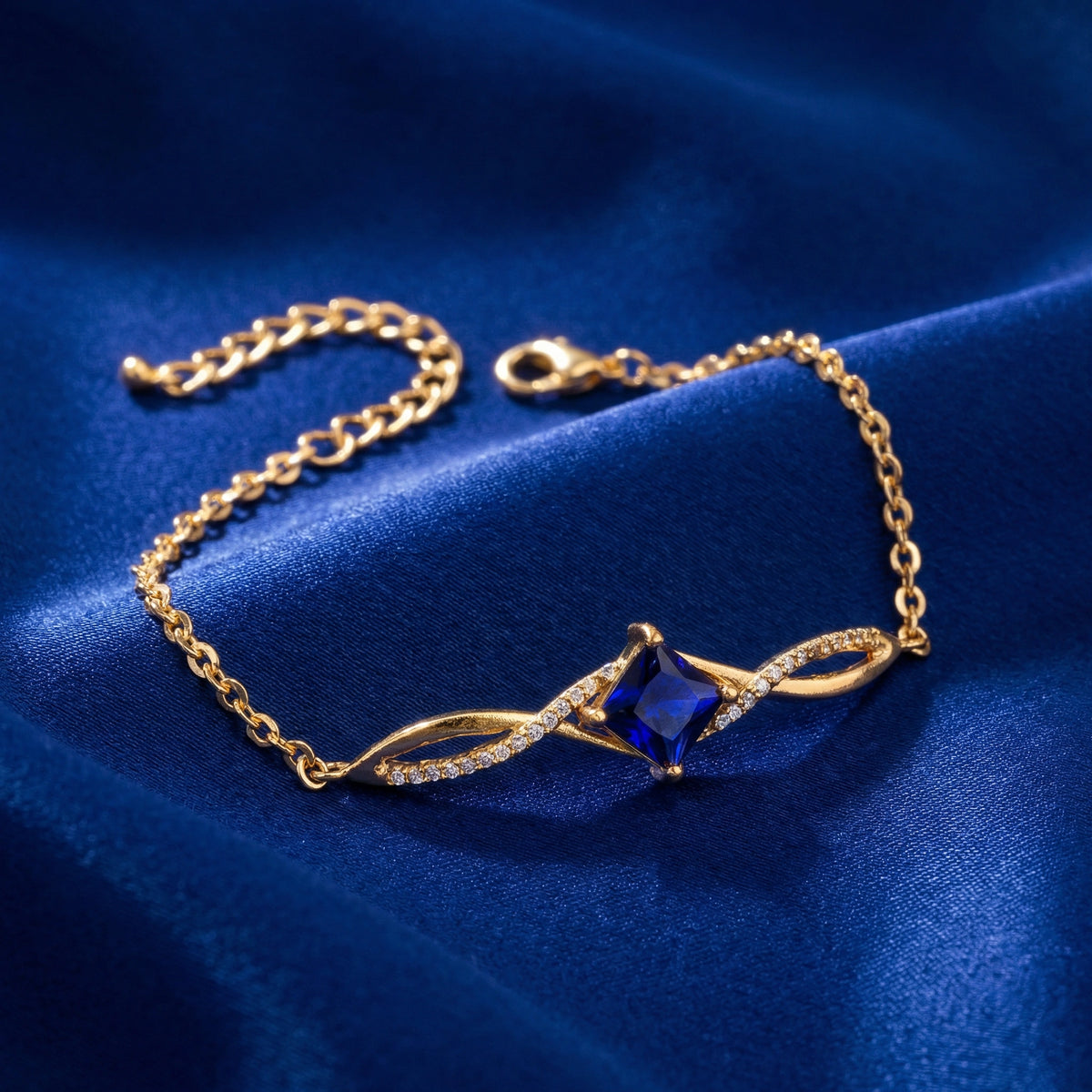 18k gold plated bracelet with a blue gemstone on a blue fabric background