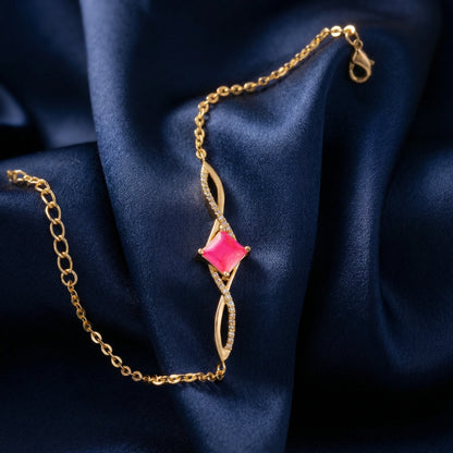 18k Gold plated bracelet with a pink gemstone on a blue fabric background