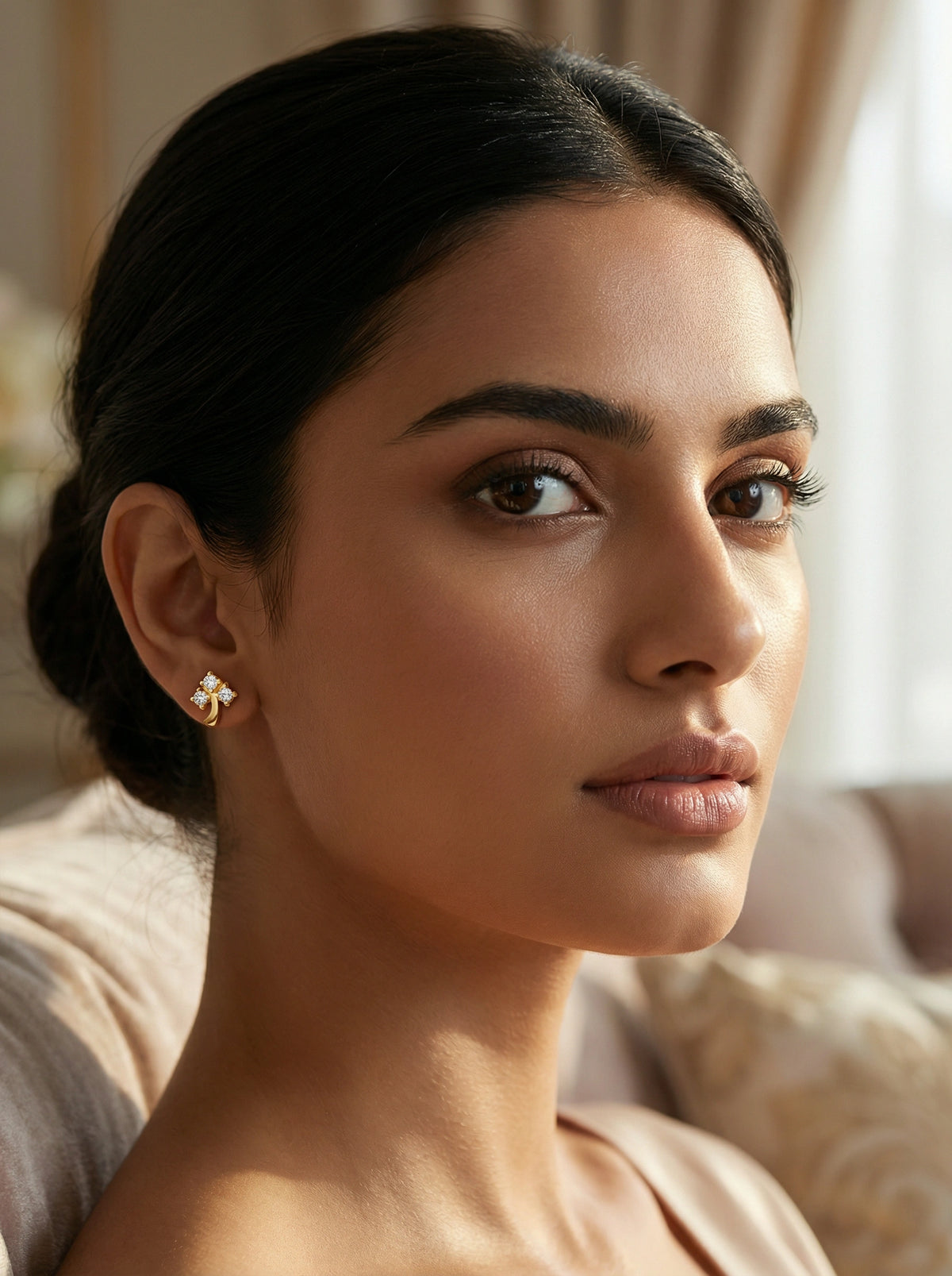 woman wearing a 18k  gold plated earring in a softly lit room