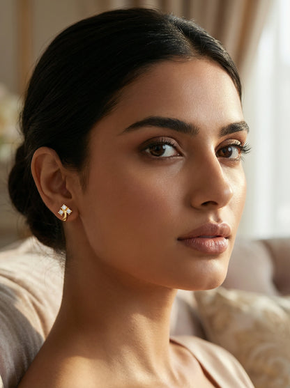 Woman wearing a 18k  gold plated earring in a softly lit room
