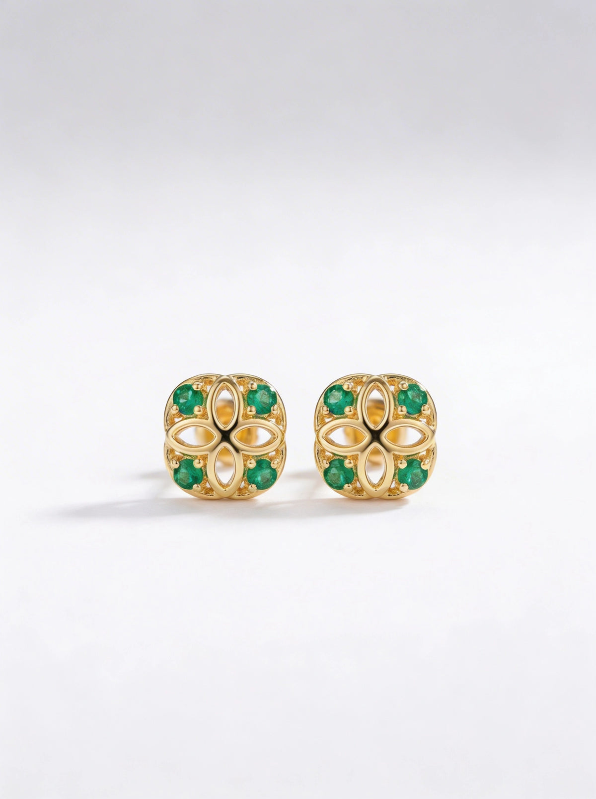 18k gold plated earrings with green gemstones on a white background