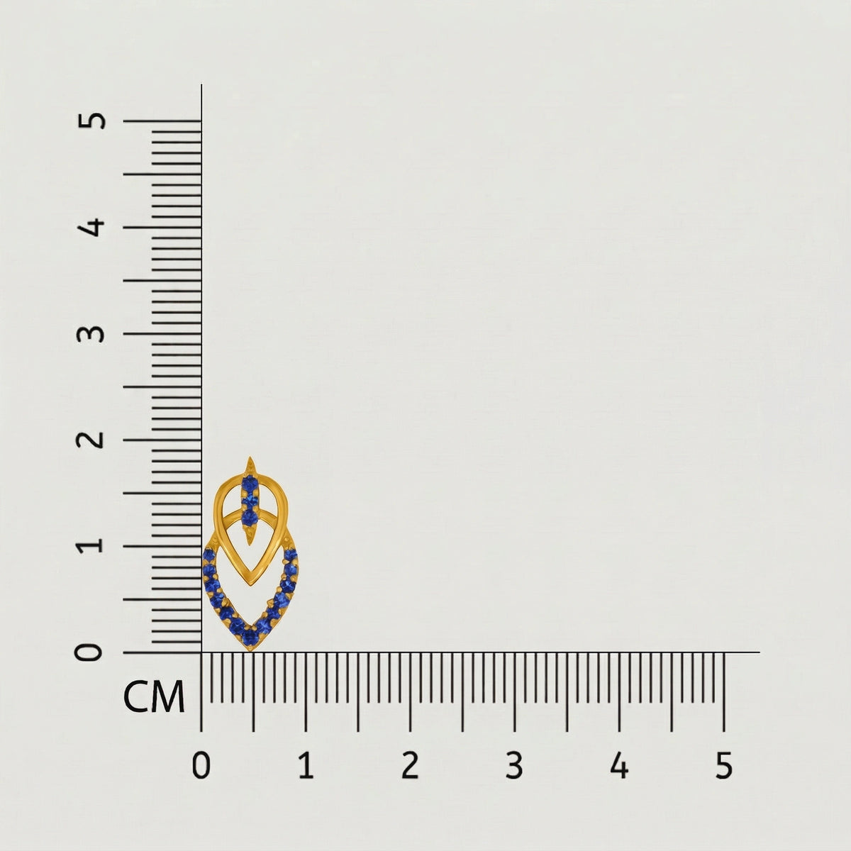jewelry with blue stones and 18k gold plated  accents next to a ruler on a gray background