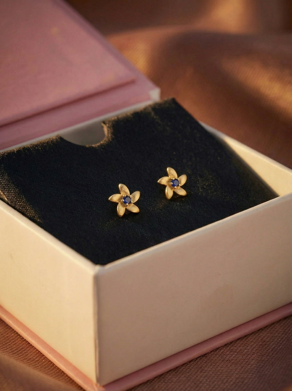 18k gold plated  flower-shaped earrings with gemstones in a jewelry box.