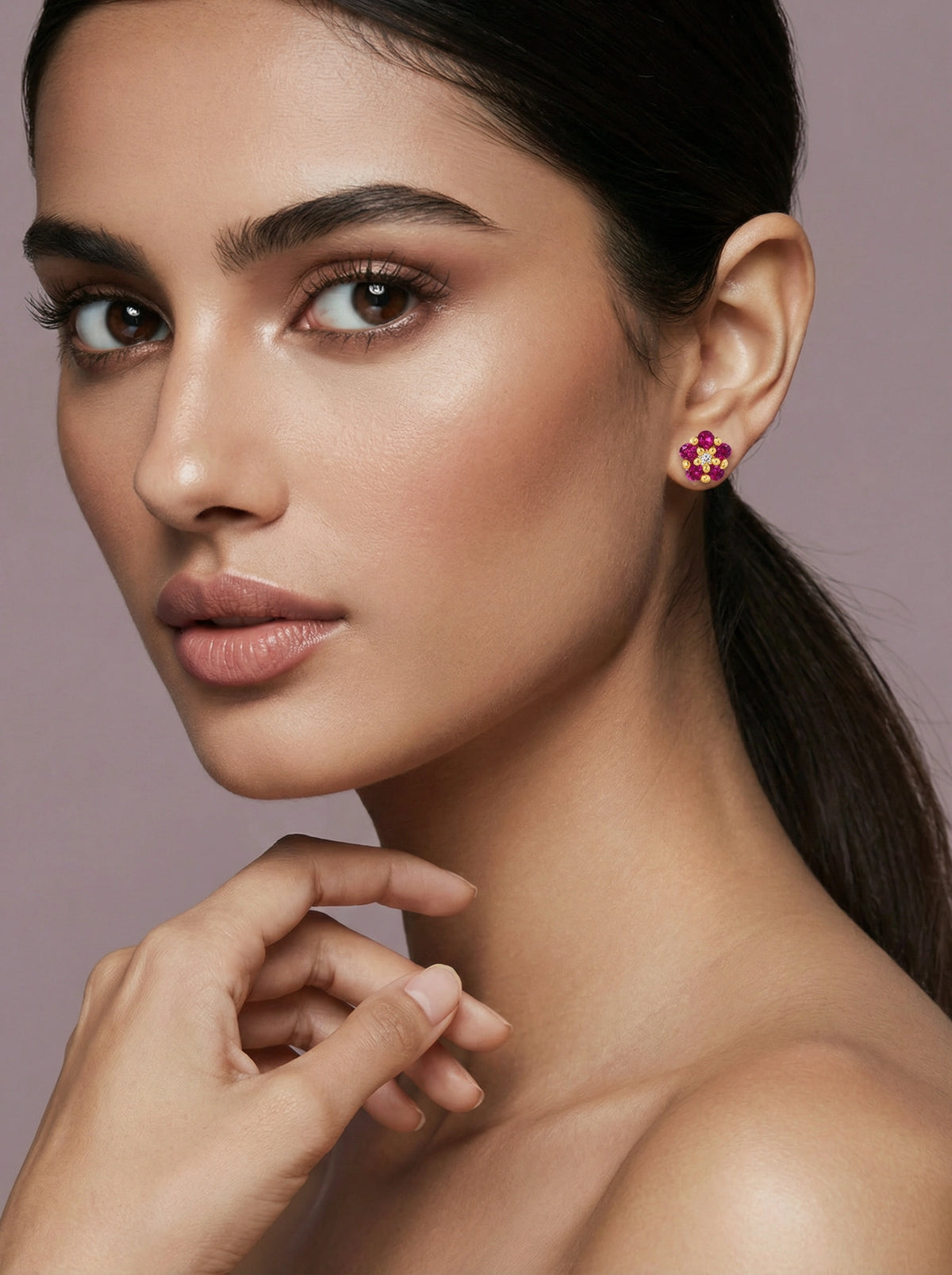 close-up of a woman wearing 18k gold plated  pink earrings with a neutral background