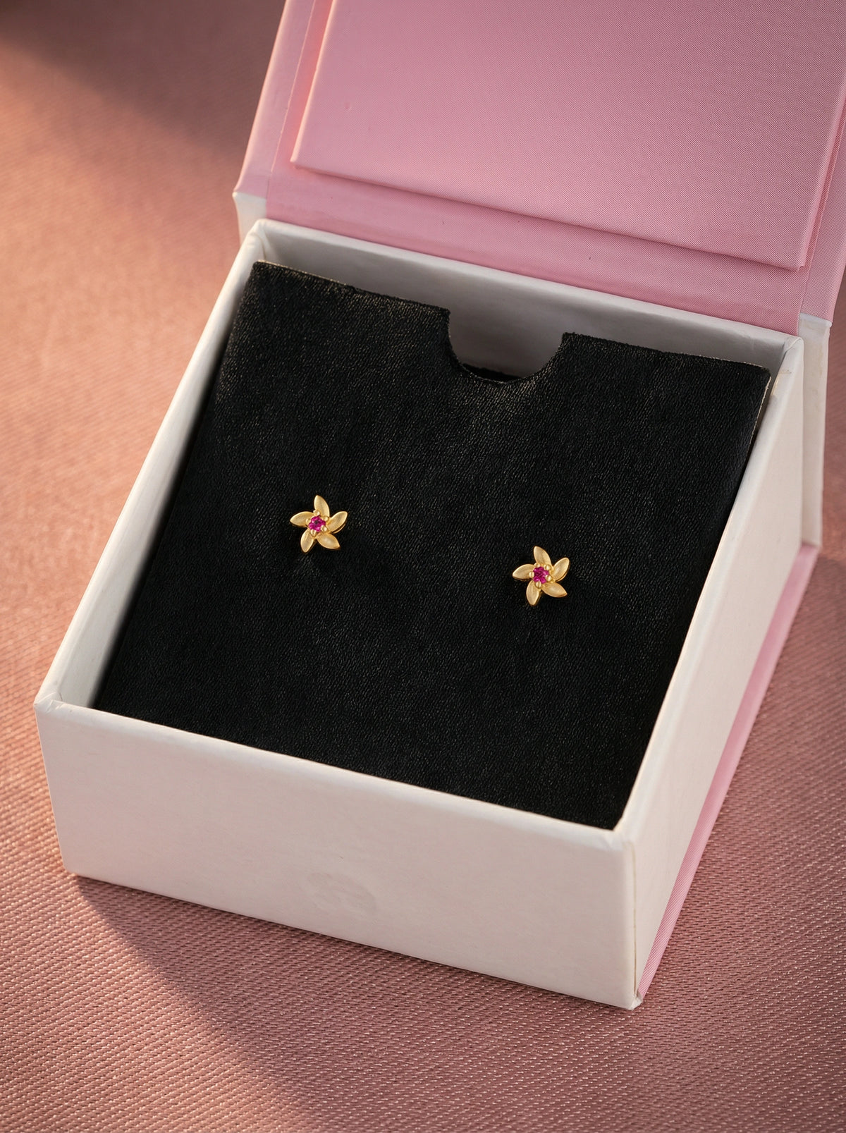 flower-shaped 18k gold plated  earrings in a jewelry box with a pink lid.