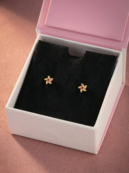 Flower-shaped 18k gold plated  earrings in a jewelry box with a pink lid.