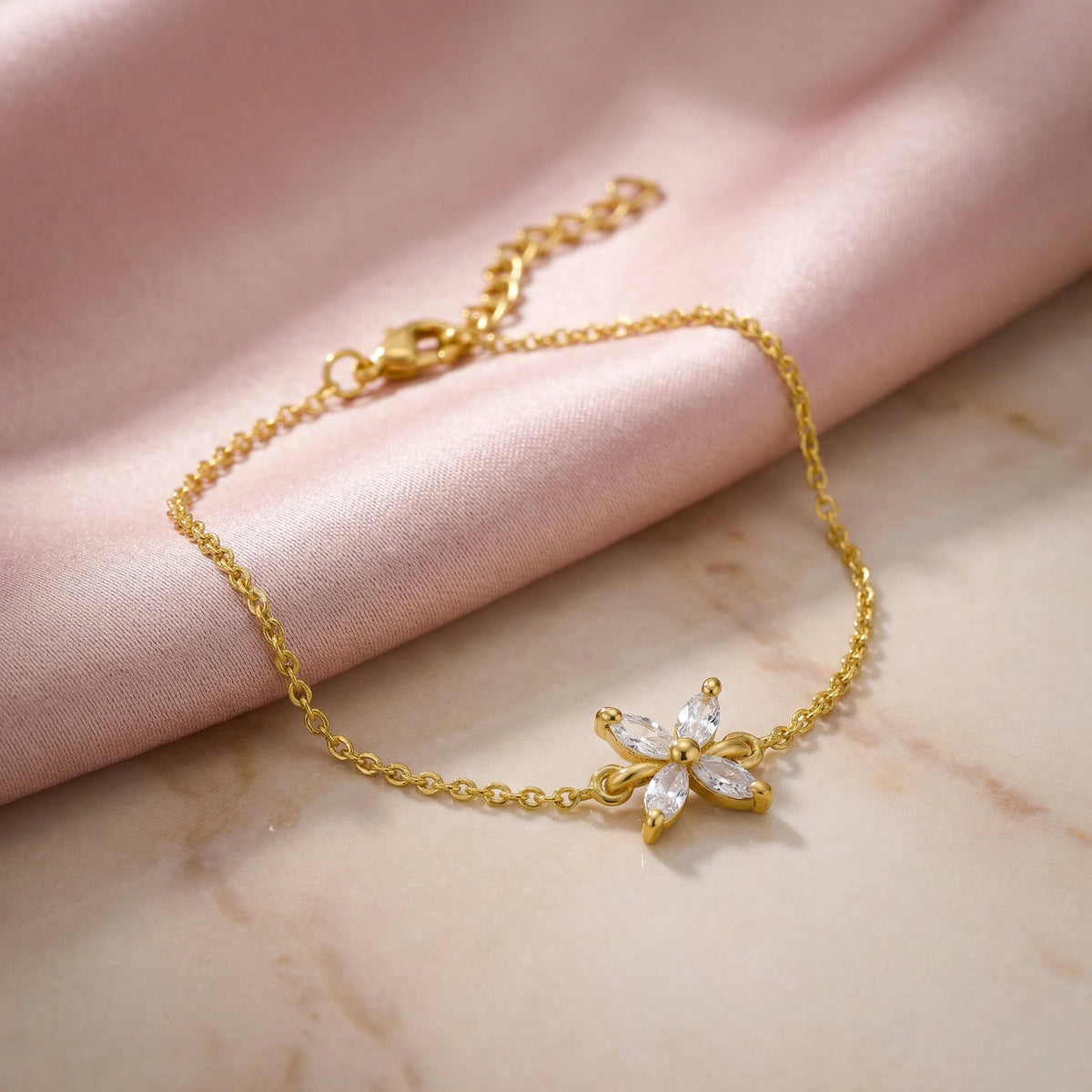 18k gold plated bracelet with a floral clasp on a marble surface
