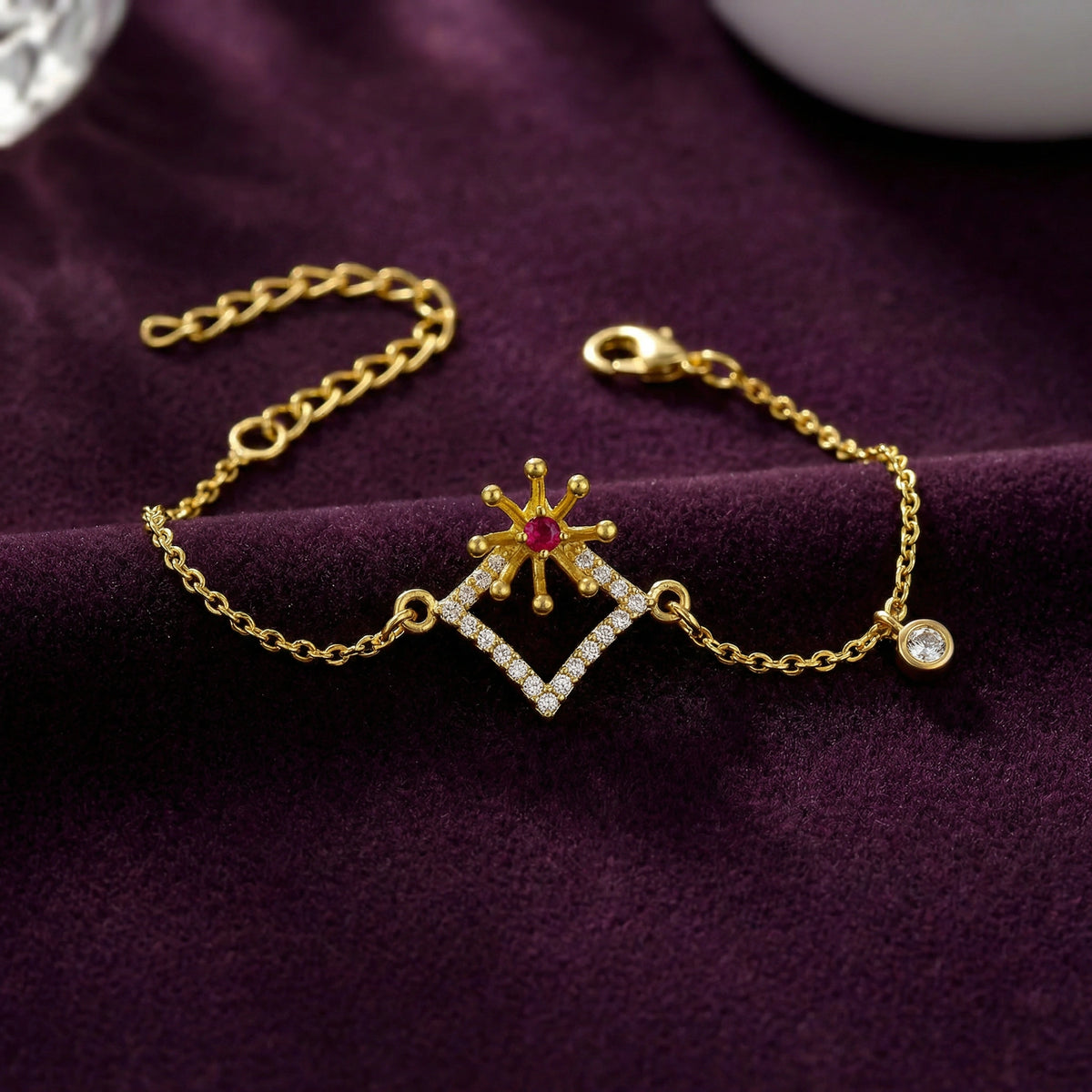 18k gold plated  bracelet with star and diamond-shaped charm on a purple fabric background