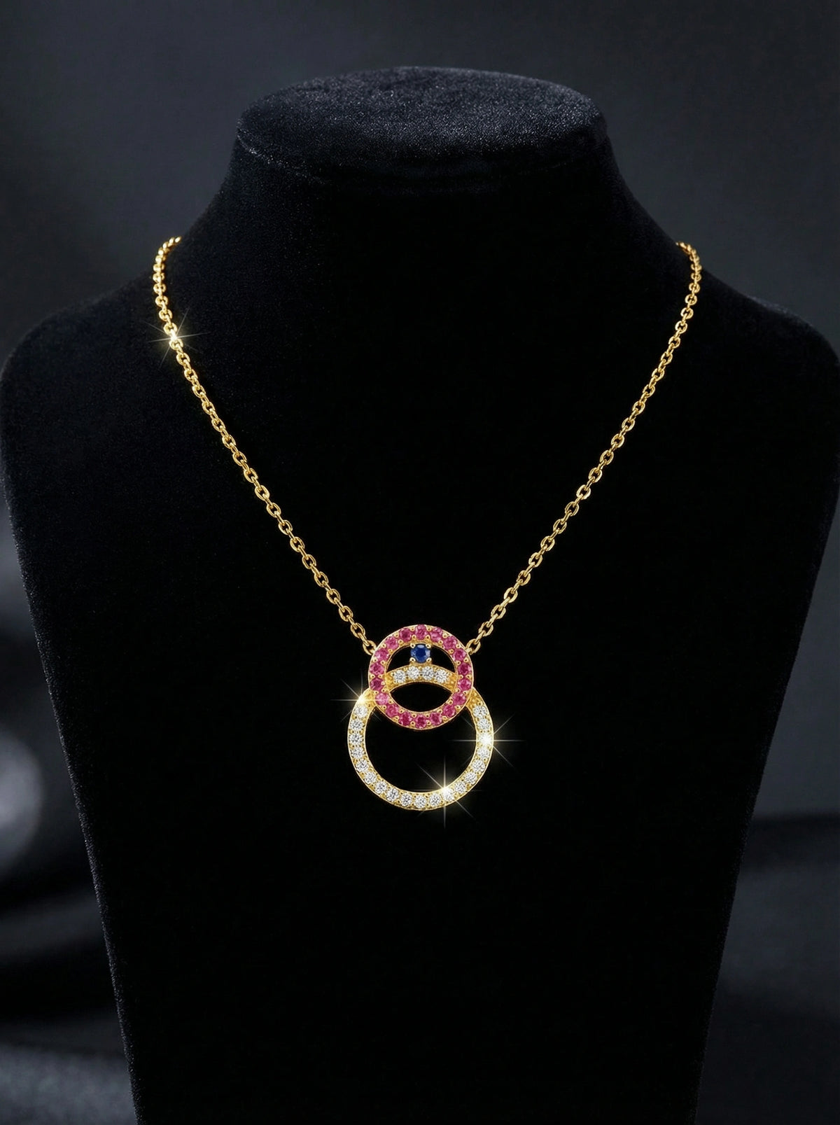 18k gold plated Necklace with interlocking rings on a black stand against a dark background