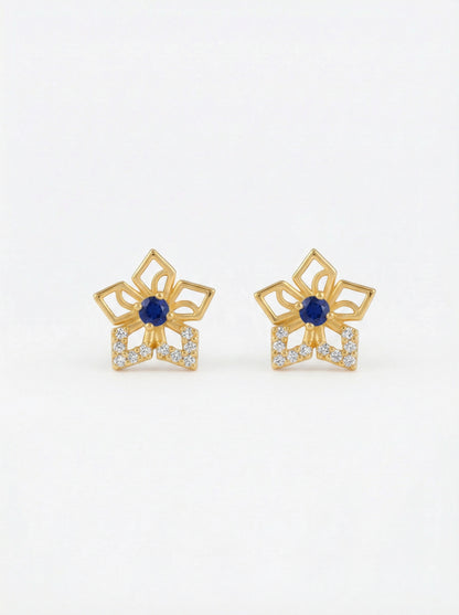 Pair of 18k gold plated earrings with blue gemstones on a white background