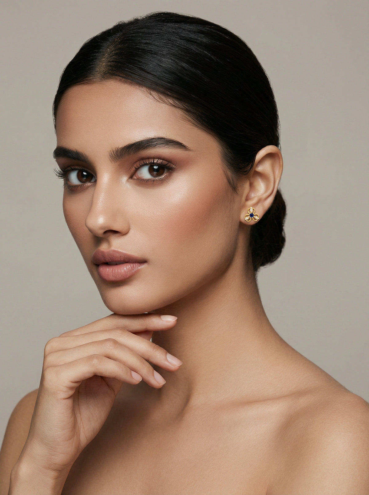 woman with a neutral expression against a beige background
