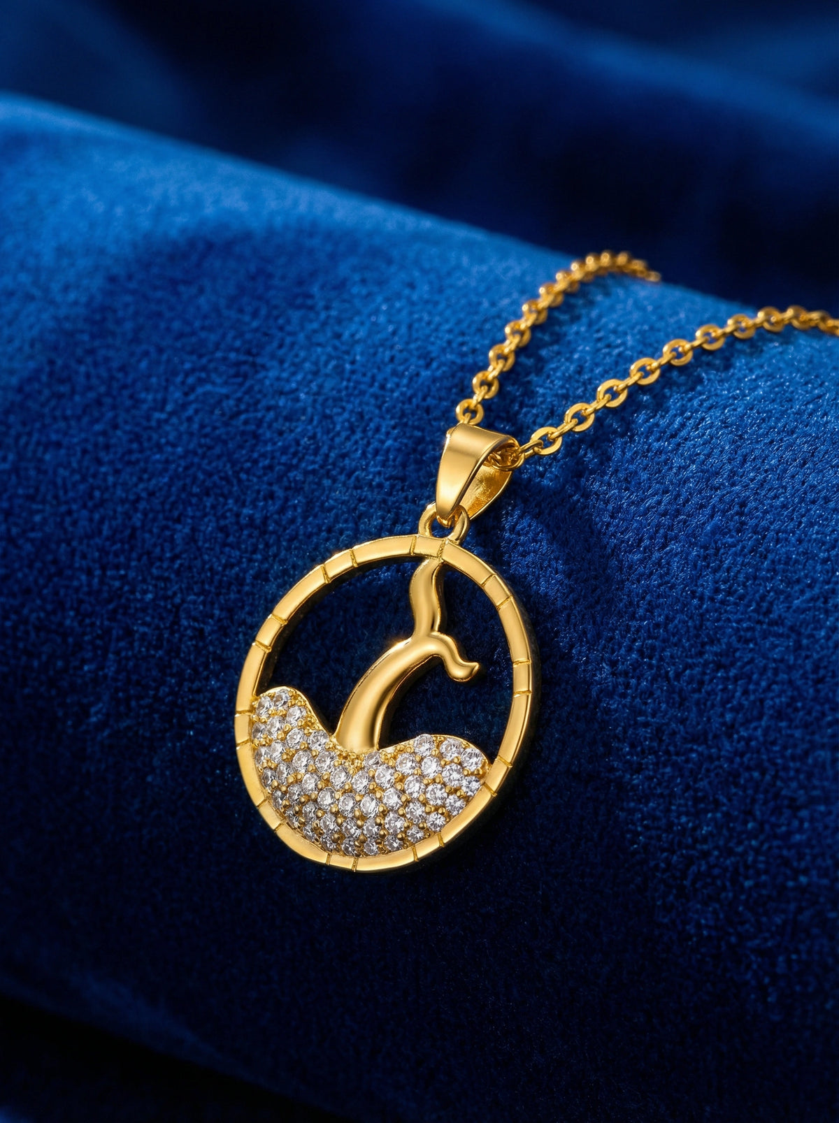 18k gold plated necklace with a circular pendant featuring a design on a blue fabric background