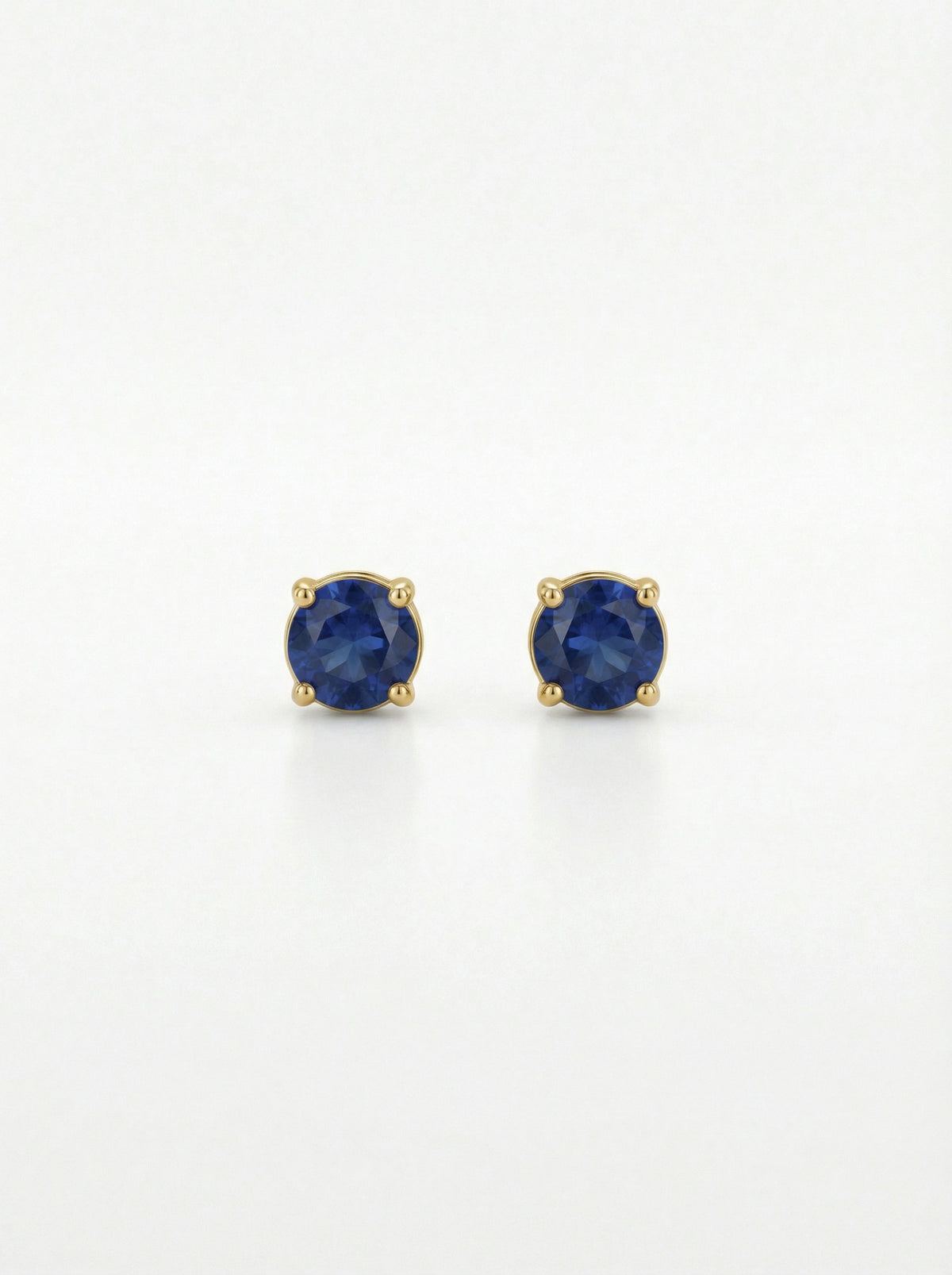 pair of 18k gold plated earrings with blue gemstones on a white background