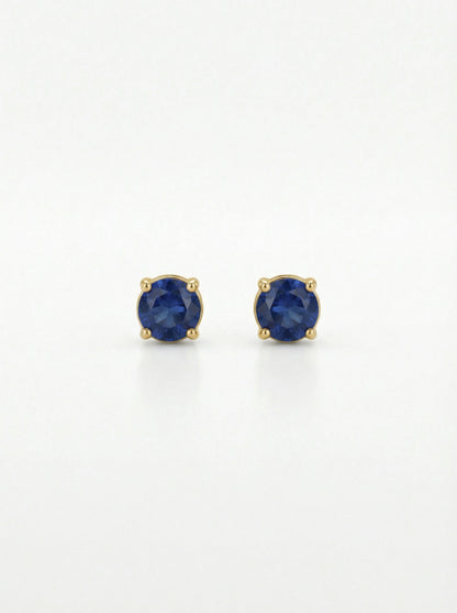 Pair of 18k gold plated earrings with blue gemstones on a white background