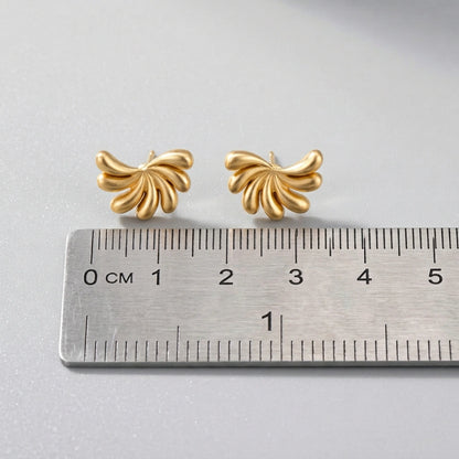 18k Gold plated butterfly-shaped earrings on a ruler for scale on a light gray background