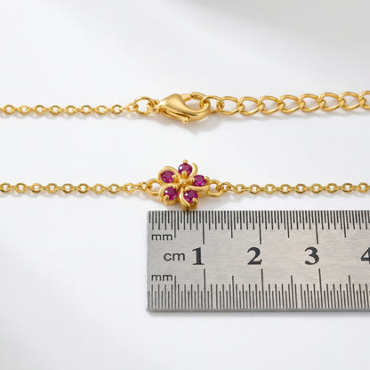 18k Gold  plated bracelet with a floral clasp next to a ruler for size reference on a white background