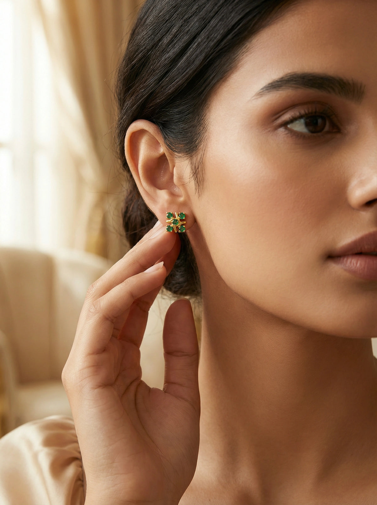 woman wearing 18k gold plated  green earrings with a blurred background