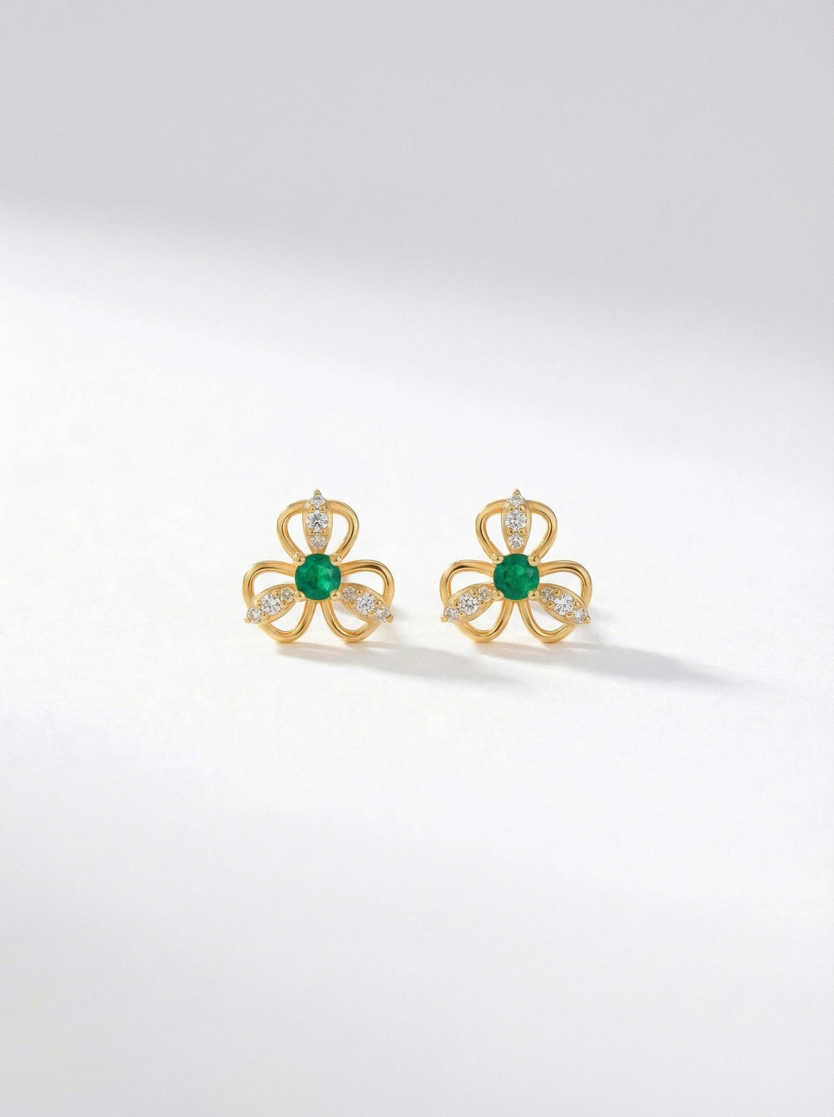 18k Gold plated earrings with green gemstones on a white background