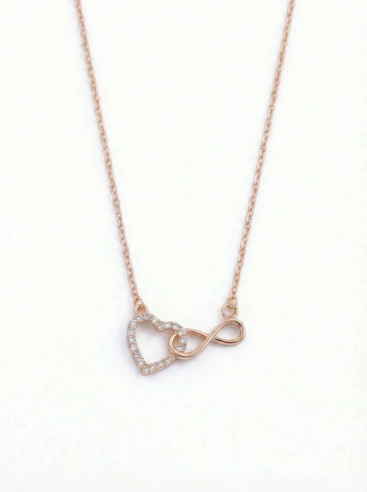  18k rose gold plated necklace with heart and infinity symbol pendant on a white background