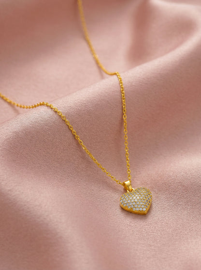 18k Gold plated heart-shaped pendant necklace on a pink fabric background