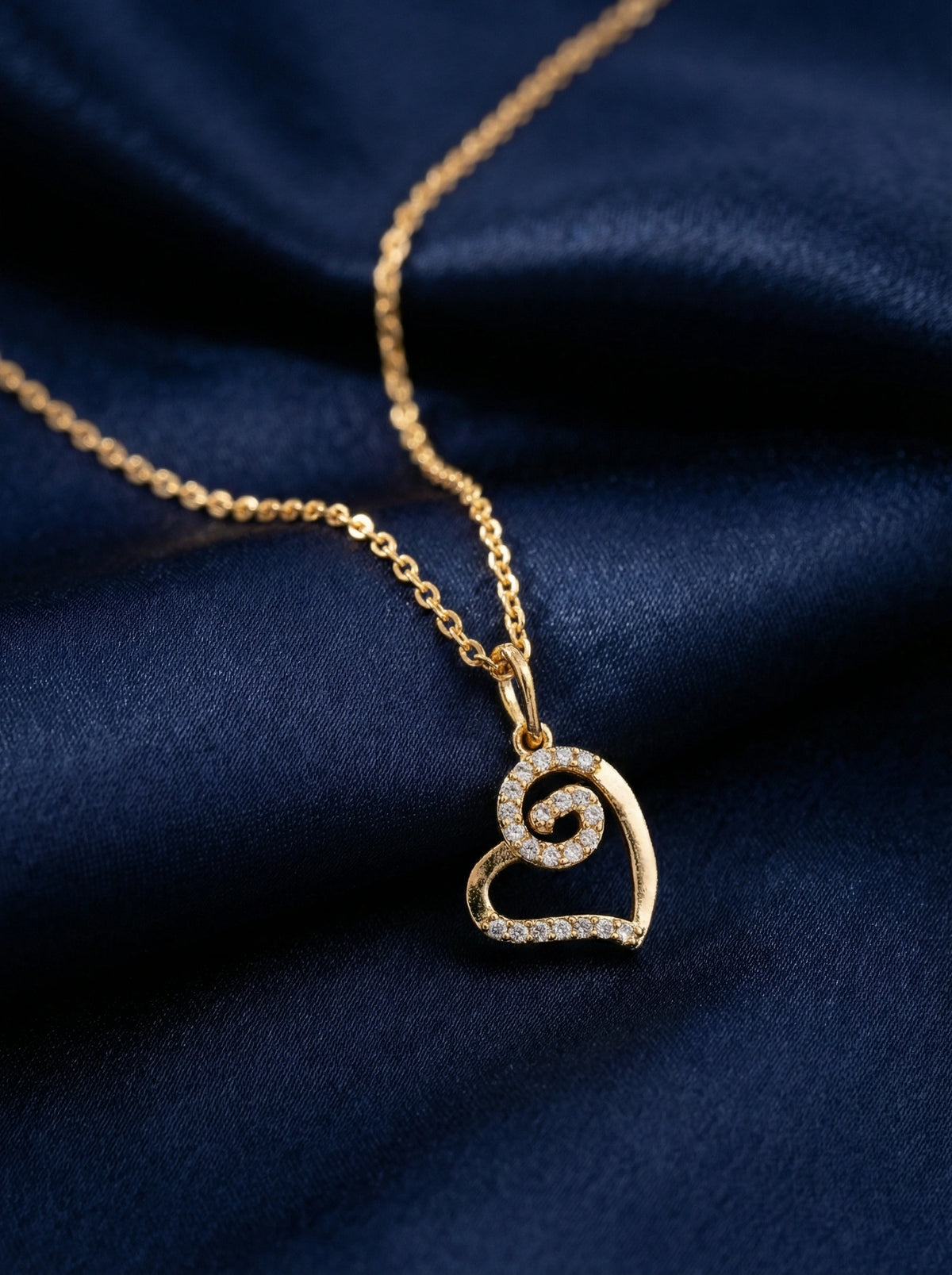 18k Gold plated necklace with a heart-shaped pendant on a dark blue fabric background