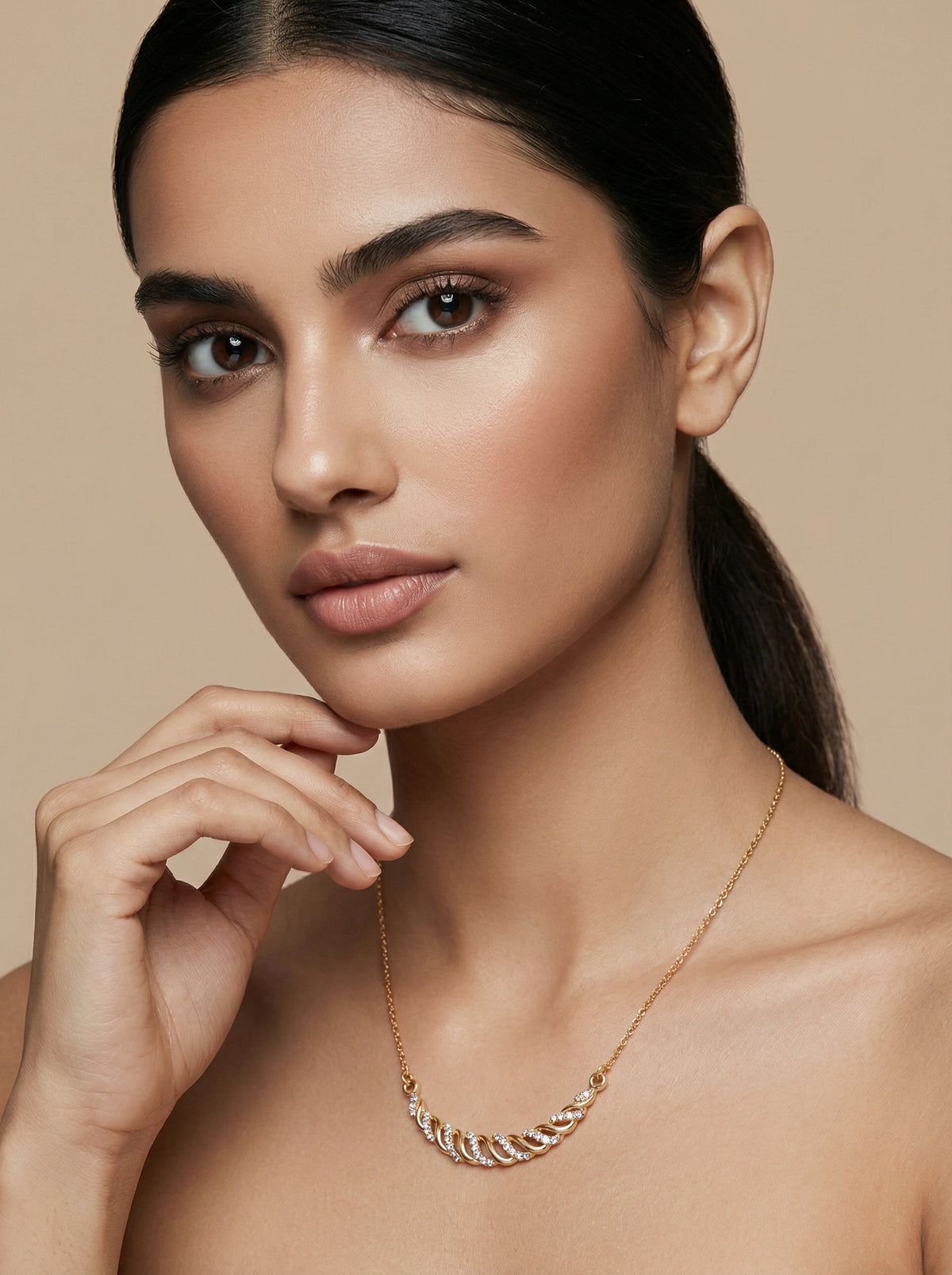 woman wearing a 18k  gold plated necklace against a beige background