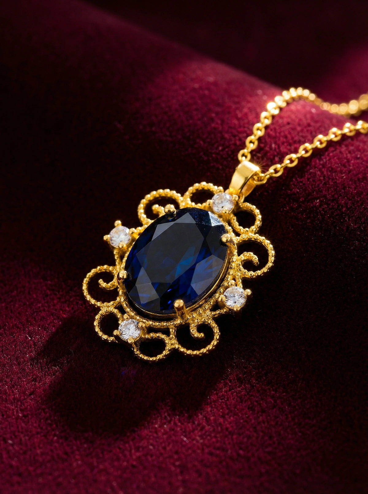 18k gold plated necklace with a blue gemstone pendant on a red fabric background
