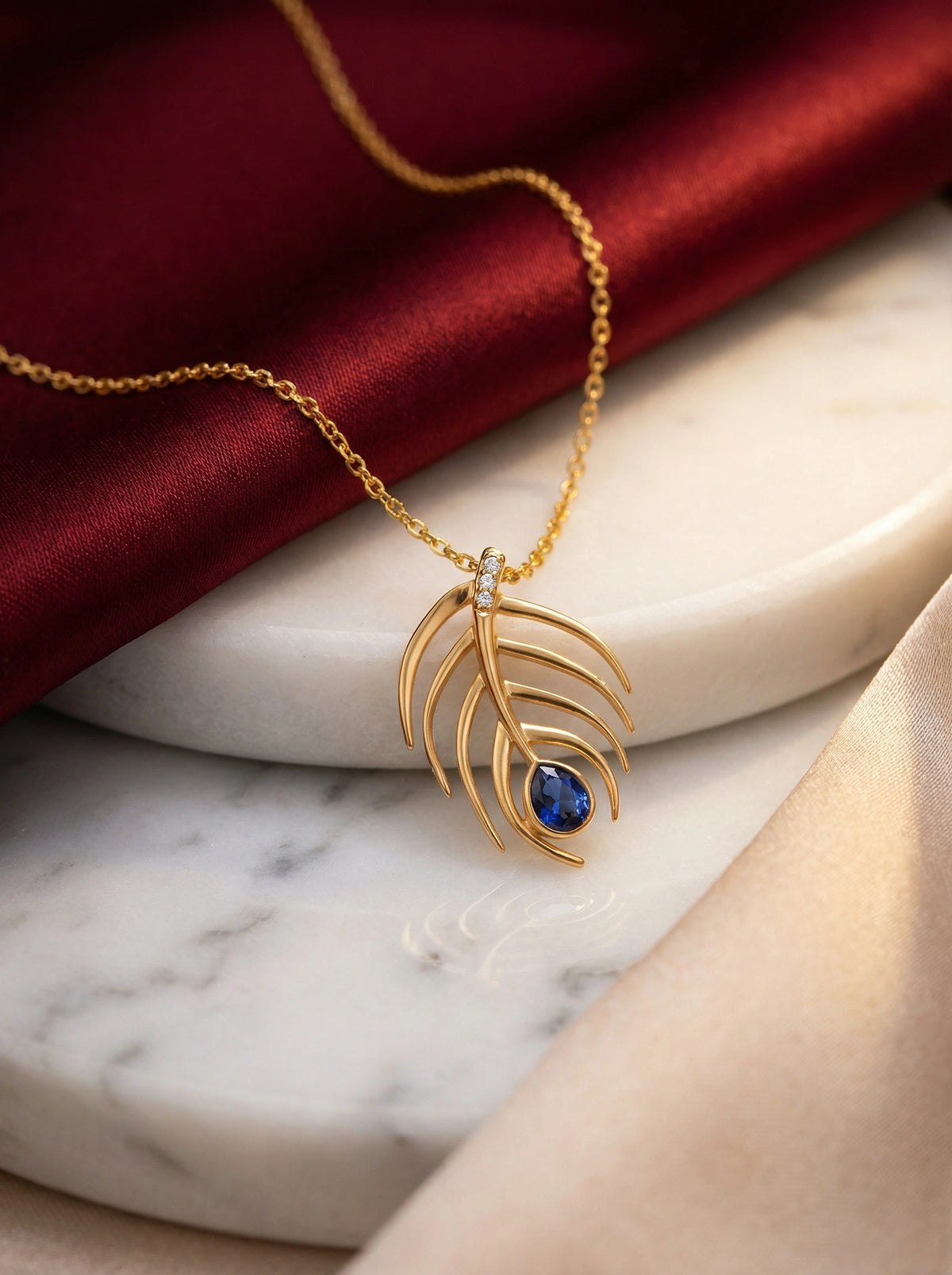 18k gold plated necklace with a blue gemstone pendant on a marble surface