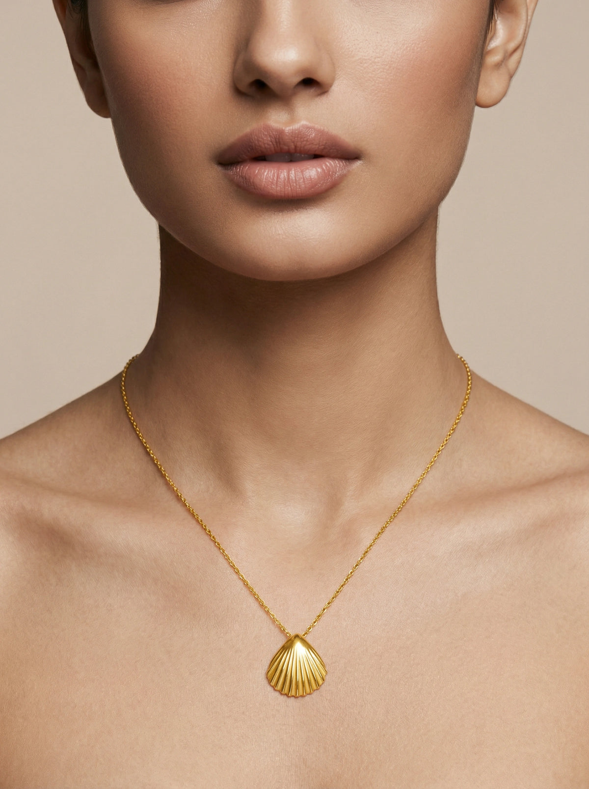18k gold plated necklace with a shell pendant on a neutral background