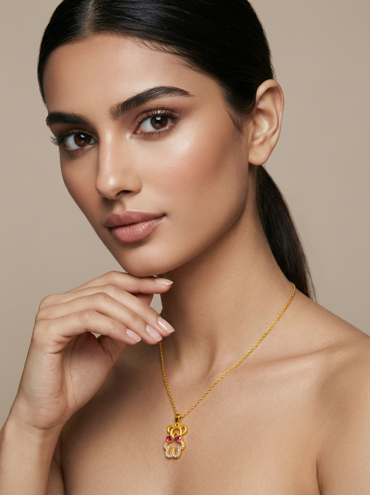 woman wearing a 18k gold plated necklace against a beige background