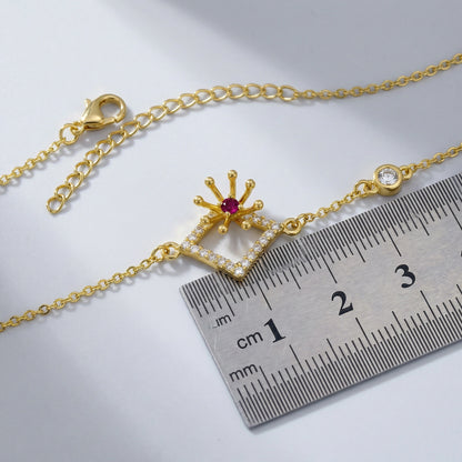 18k Gold plated bracelet with a decorative clasp next to a ruler on a light gray background