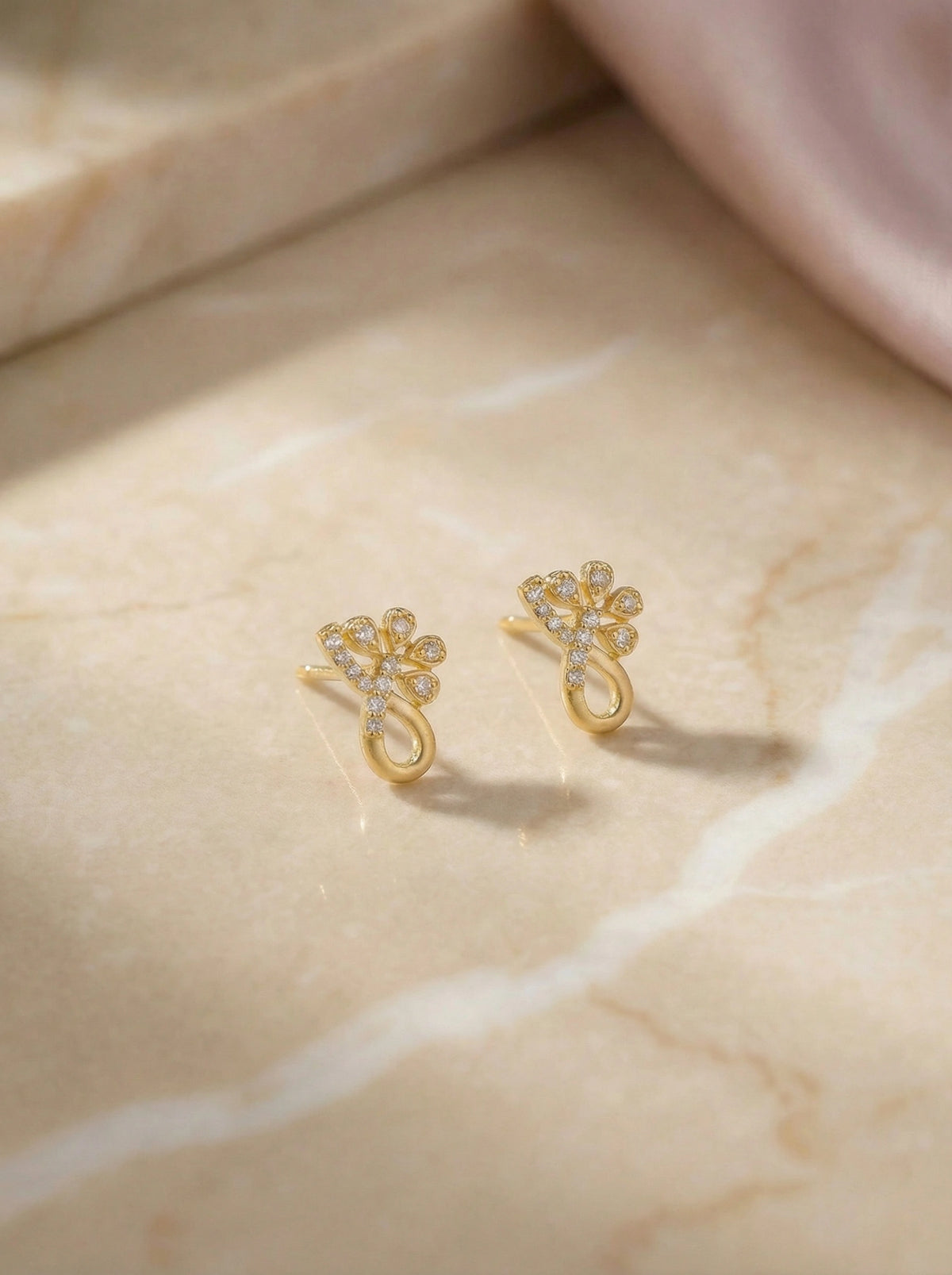 18k gold plated earrings on a marble surface