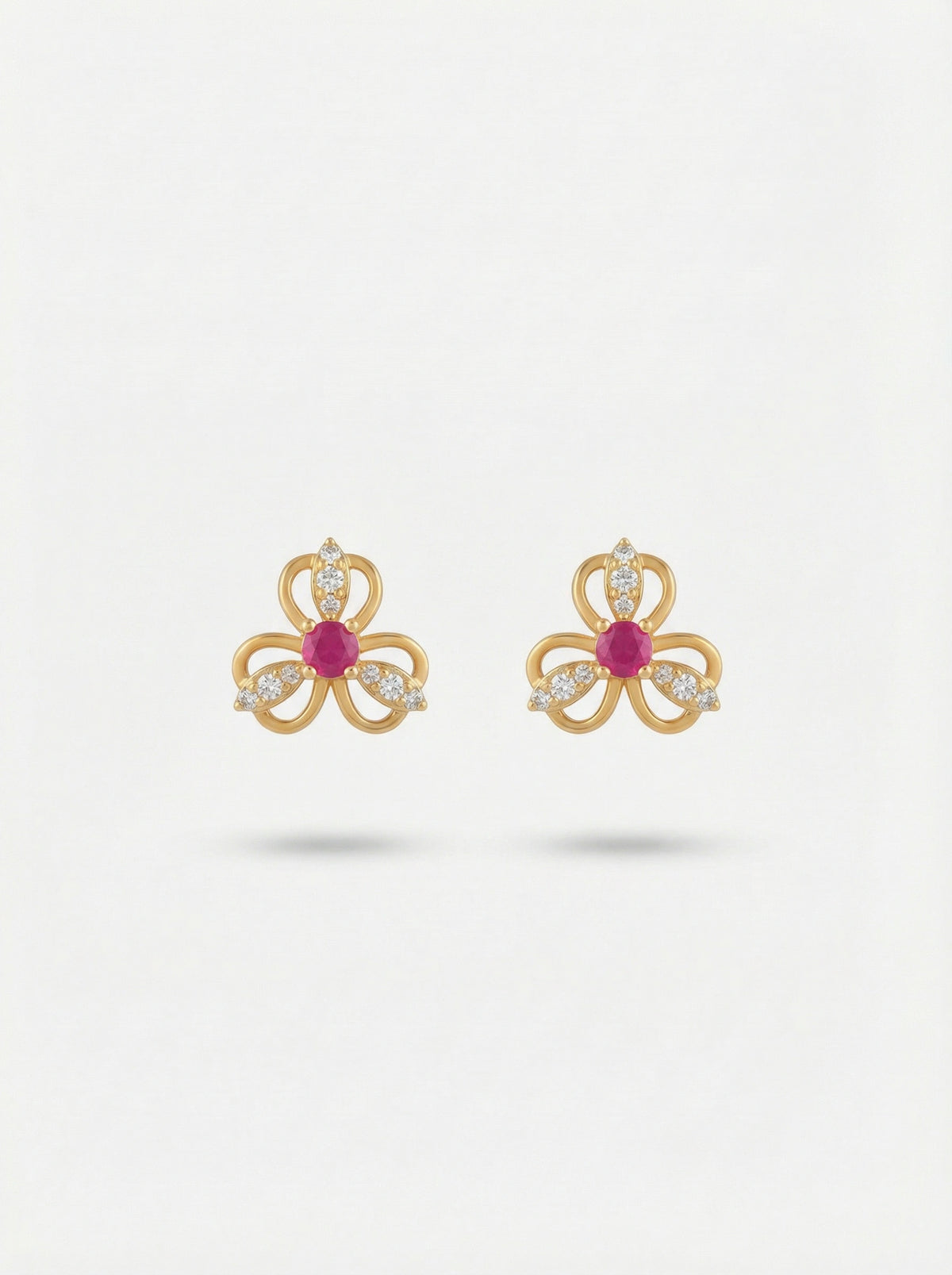 18k Gold plated bow-shaped earrings with red gemstones on a white background