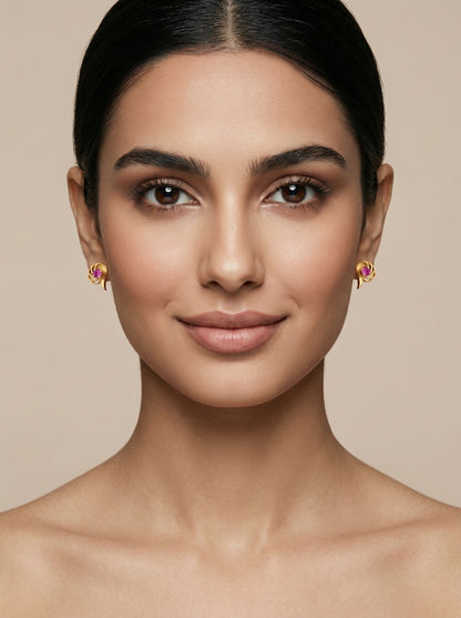 Woman wearing 18k gold plated earrings with a neutral background