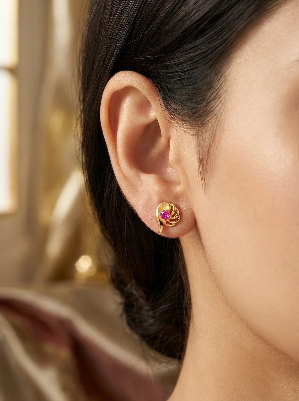 18k gold plated earring with a purple gemstone worn by a person