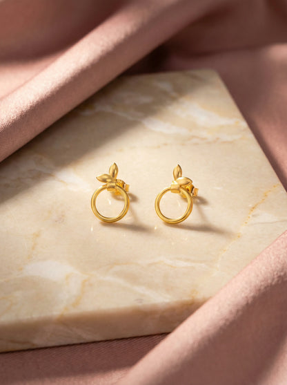 18k Gold plated earrings on a marble surface with a soft pink fabric background