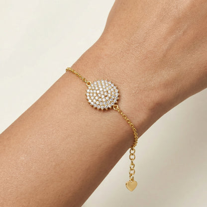 18k Gold plated bracelet with a heart charm on a wrist against a beige background